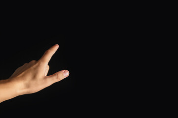 Man touching something on black background, closeup. Space for text