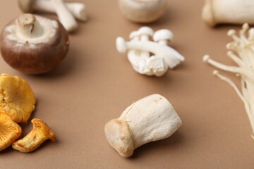 Different raw mushrooms on beige background, closeup