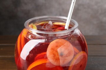 Tasty fruity punch on wooden table, closeup. Refreshing drink