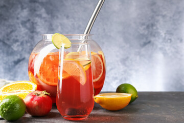 Punch and fresh fruits on grey table, space for text. Refreshing drink