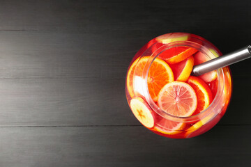 Fruity punch on black wooden table, top view with space for text. Refreshing drink