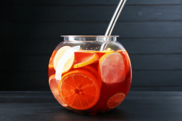 Fruity punch on black wooden table. Refreshing drink