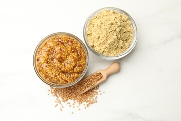 Different types of mustard on white marble table, flat lay