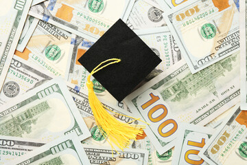 Scholarship. Graduate hat on dollar banknotes, top view