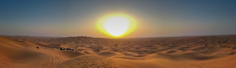 Panoramic view of the golden sunset over the desert dunes in the UAE.