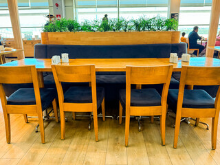 Wooden cafe table with chairs in modern interior. Social dining, hospitality, and casual lifestyle in public space.