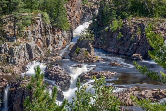 Aubrey Falls in Ontario offers a stunning view with cascading waters surrounded by lush forest and rugged rocks.