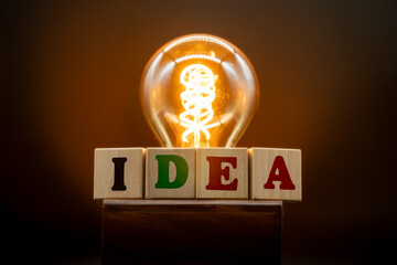 Concept - a glowing light bulb symbolizing an idea, a corporate brainstorming session. The inscription "IDEA." creative invention, thought, innovation, creativity