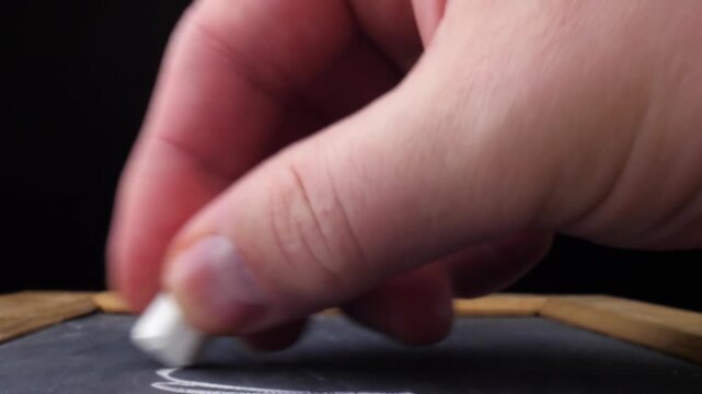 Hand Demonstrating Chalk Writing ABCD on Blackboard