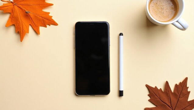 "Cozy autumn workspace with smartphone, pen, coffee, and leaves