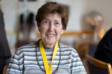 Portrait einer Seniorin im Seniorenheim mit Schlüsselband