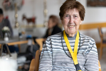 Portrait einer Seniorin im Seniorenheim mit Schlüsselband