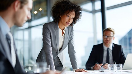 Confident Black woman leading a business meeting in a modern office.