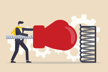 Businessman with boxing glove punching a spring mechanism with gears in the background representing business challenges and solutions