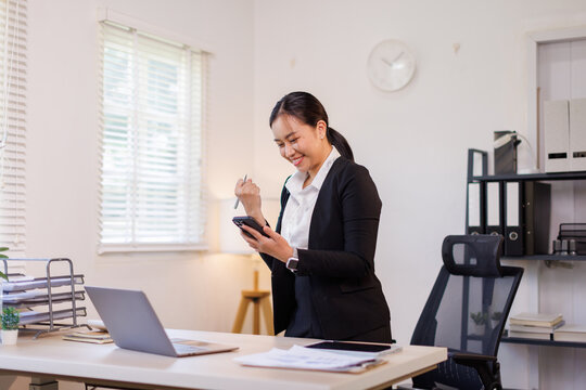 Stylish smiling face happy asian business woman manager working on laptop while sitting in office. financial report, business plan investment, finance analysis concept. High quality photo
 - Powered by Adobe