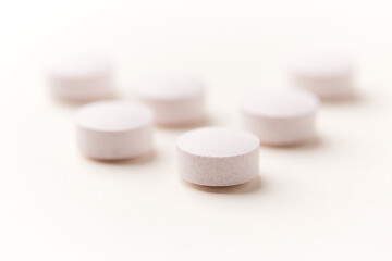 Creatine tablets on paper background. Soft focus. Close up. Copy space.	