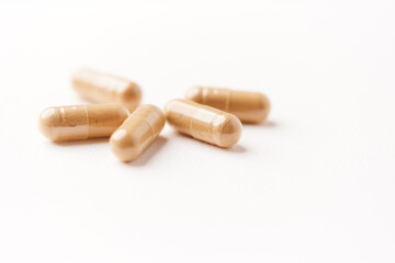 Ashwagandha (Withania somnifera) capsules. Concept for a healthy dietary supplementation. Bright paper background. Close up. Copy space.	