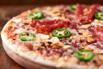 Pizza with salami, mozzarella cheese and jalapeno pepper. Wooden background. Soft focus. Copy space.	