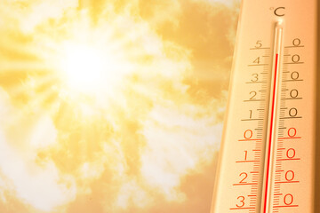 Extremely high temperature on thermometer against orange sky on sunny day. Severely hot summer weather
