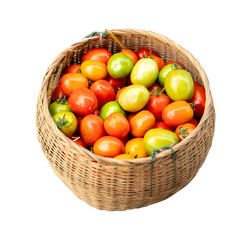 A fresh basket of juicy red tomatoes is isolated on a white background