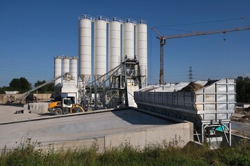 Obraz premium Scenery of concrete factory with white silos for production of concrete 