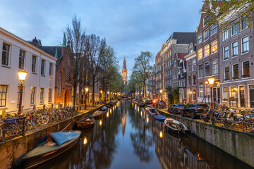 Amsterdam, Netherlands - March 30, 2024: Canal in the Old Town of Amsterdam in the evening time.