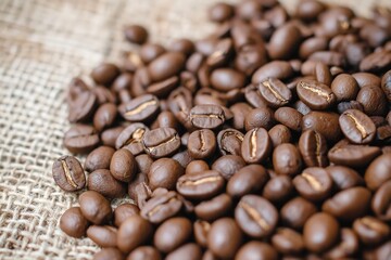 Obraz premium A Rich and Aromatic Collection of Roasted Coffee Beans Spread Beautifully on a Rustic Jute Fabric Background