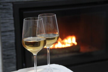 Glasses of white wine by the fireplace