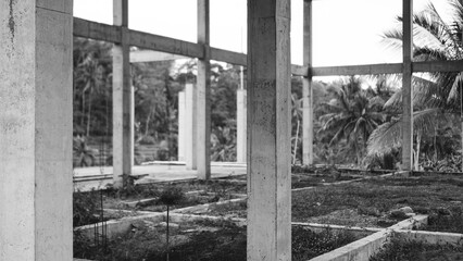 Monochrome view of a building under construction, showcasing concrete columns.