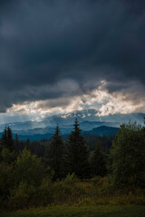 Dramatic Clouds Over Forested Mountains