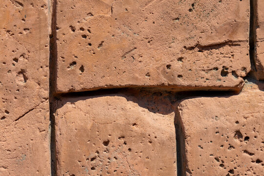 Close-Up of Orange Brick Wall with Pores and Cracks