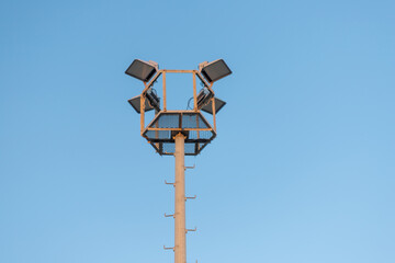 Light Pole with Floodlights Against Blue Sky