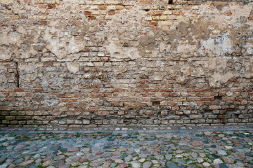 Grunge brick wall and stone pavement street