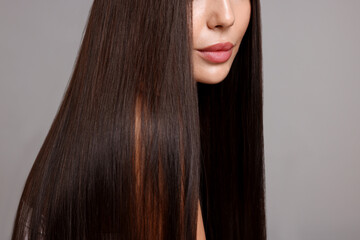 Woman with beautiful smooth hair after lamination procedure on light grey background, closeup