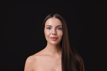 Woman with beautiful smooth hair after lamination procedure on black background
