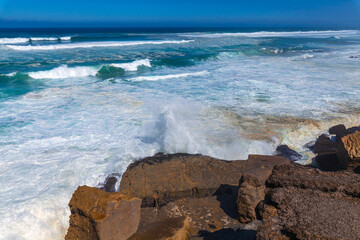 Powerful waves crash against rugged coastal rocks
