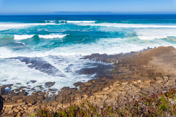 Powerful waves crash against rugged coastal rocks
