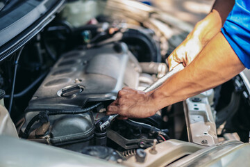 A man is working on a car engine