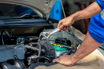 A mechanic is working on a car engine