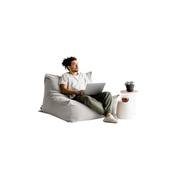 Relaxed Young Man Working on Laptop from Comfortable Bean Bag Chair at Home