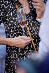 Woman holding glass of rosé wine at social event