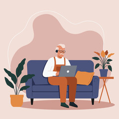 Elderly man in headphones focused on his laptop while relaxing on a sofa at home, representing senior digital connection and modern remote living.