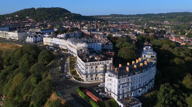 Aerial cityscape of Scarborough in the morning, showing rows of rooftops, historic architecture, and the urban layout of the town with parks and streets.