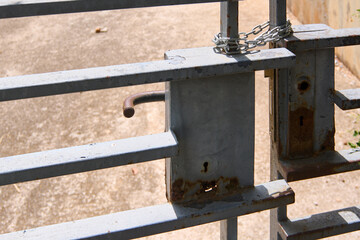 Detail of a metal gate with a rusty lock.