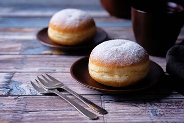 Berliner donuts with powdered sugar topping in a plate