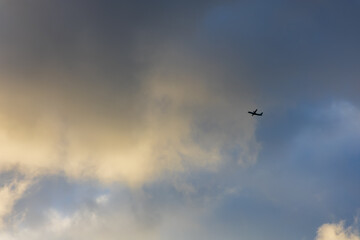 Fototapeta premium Interesting clouds in the sky. Airplane among the clouds