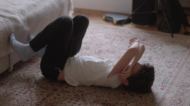A young boy lies on the floor, expressing emotions through playful movements. Captures the essence of childhood and creativity.