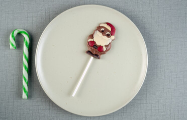 Chocolate santa pop on a plate with candy cane