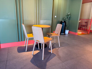 Wooden chairs and round table in a cafe. Minimalism, modern lifestyle, and urban dining atmosphere.