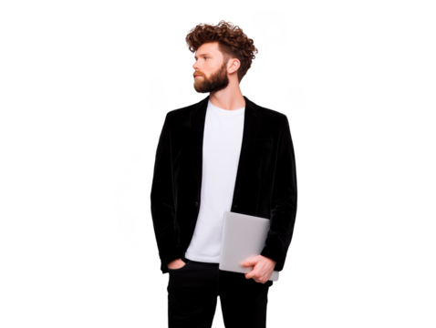 Young man with curly hair and beard wearing black blazer and white t shirt holding closed laptop, standing confidently and looking to side, isolated on transparency background